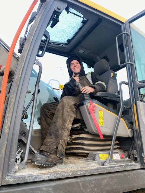 A staff from Titan Clean Energy sitting in a construction vehicle